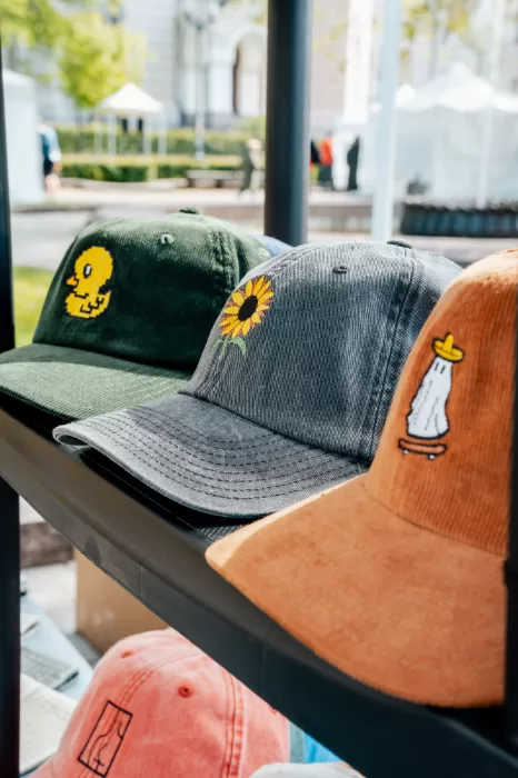 Embroidered caps close-up — pixel duck, sunflower and skating ghost on corduroy cap