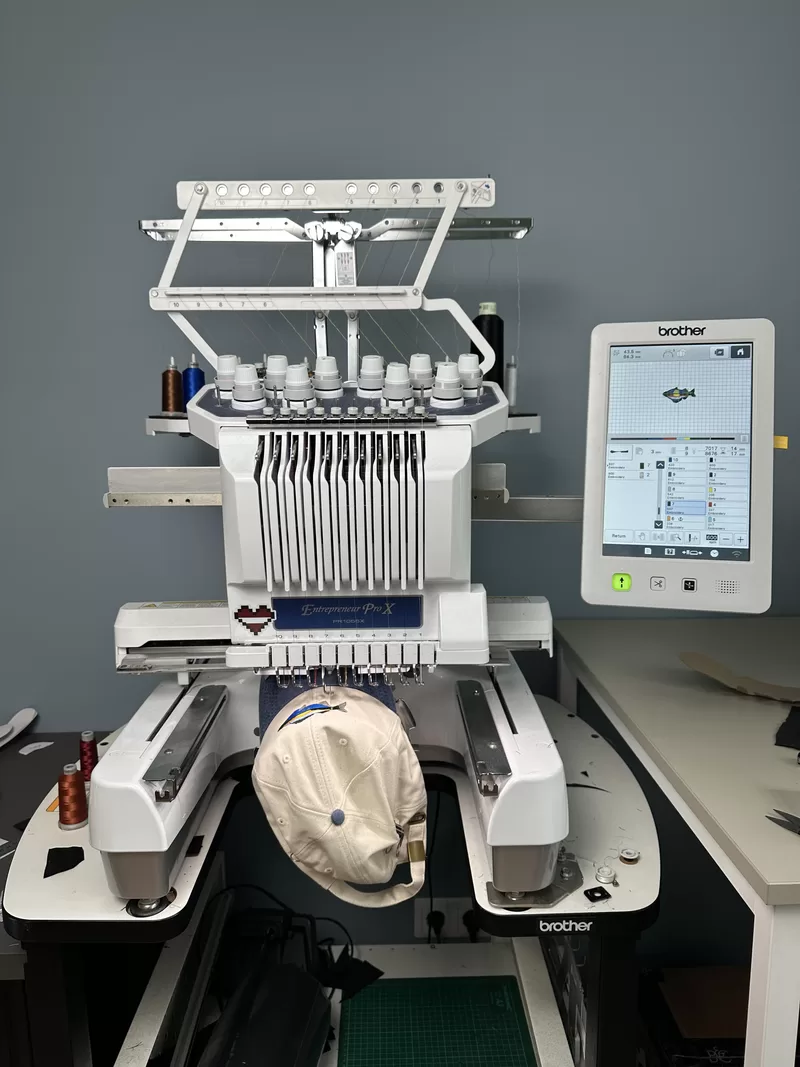 Brother Entrepreneur Pro X embroidery machine in action — cap embroidery process at Woomeleon studio